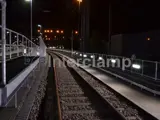 nighttime view of railway with Interclamp handrail system and pedestrian barrier