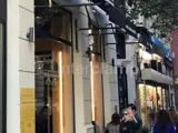 Signage support using Interclamp, on busy shop front in Europe